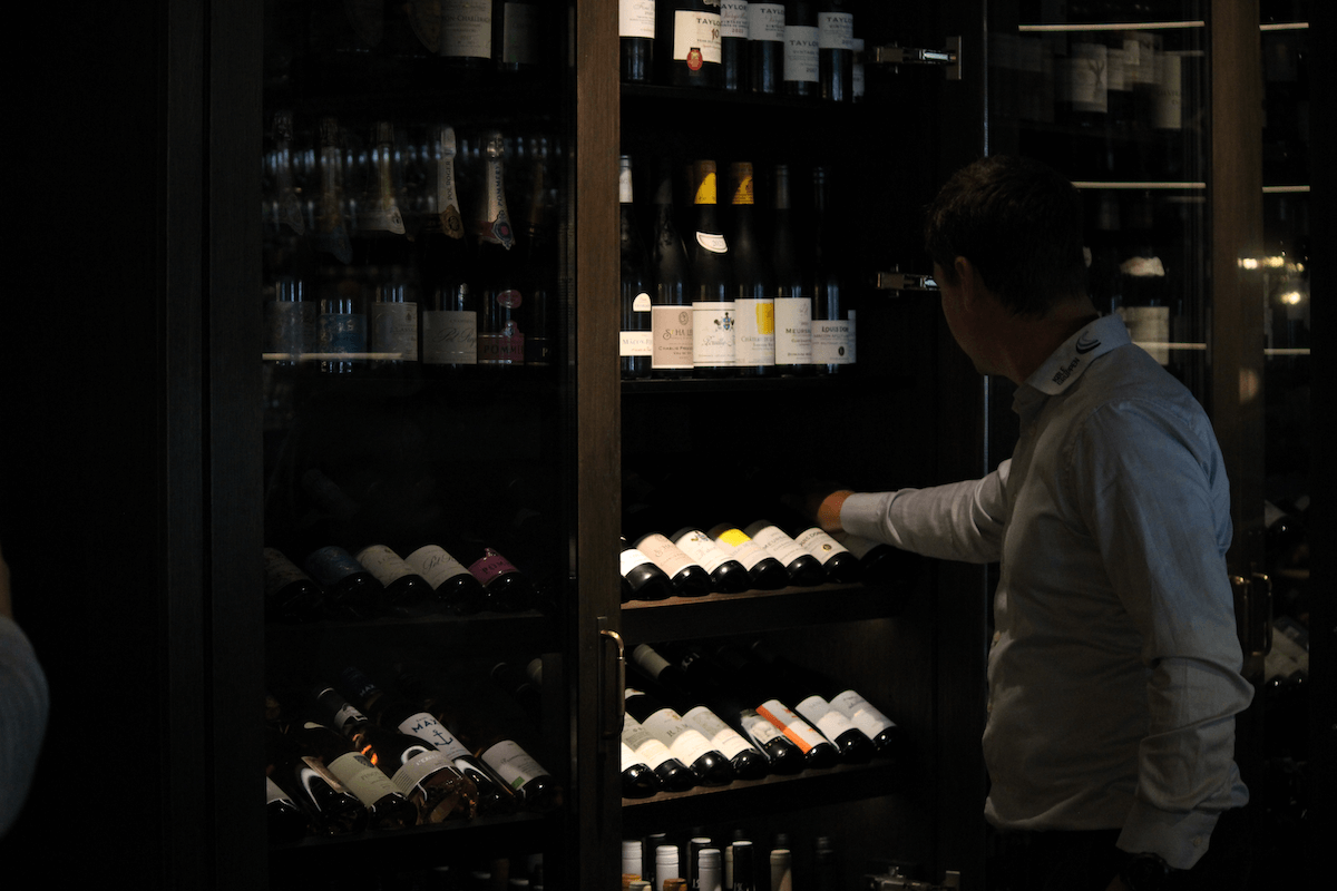 Mand tager vin ud af vinkøler